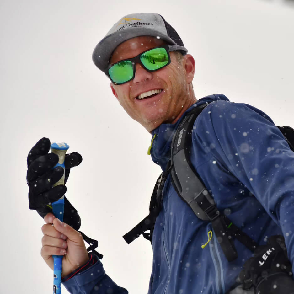 Skier with green glasses and a MindShift backpack